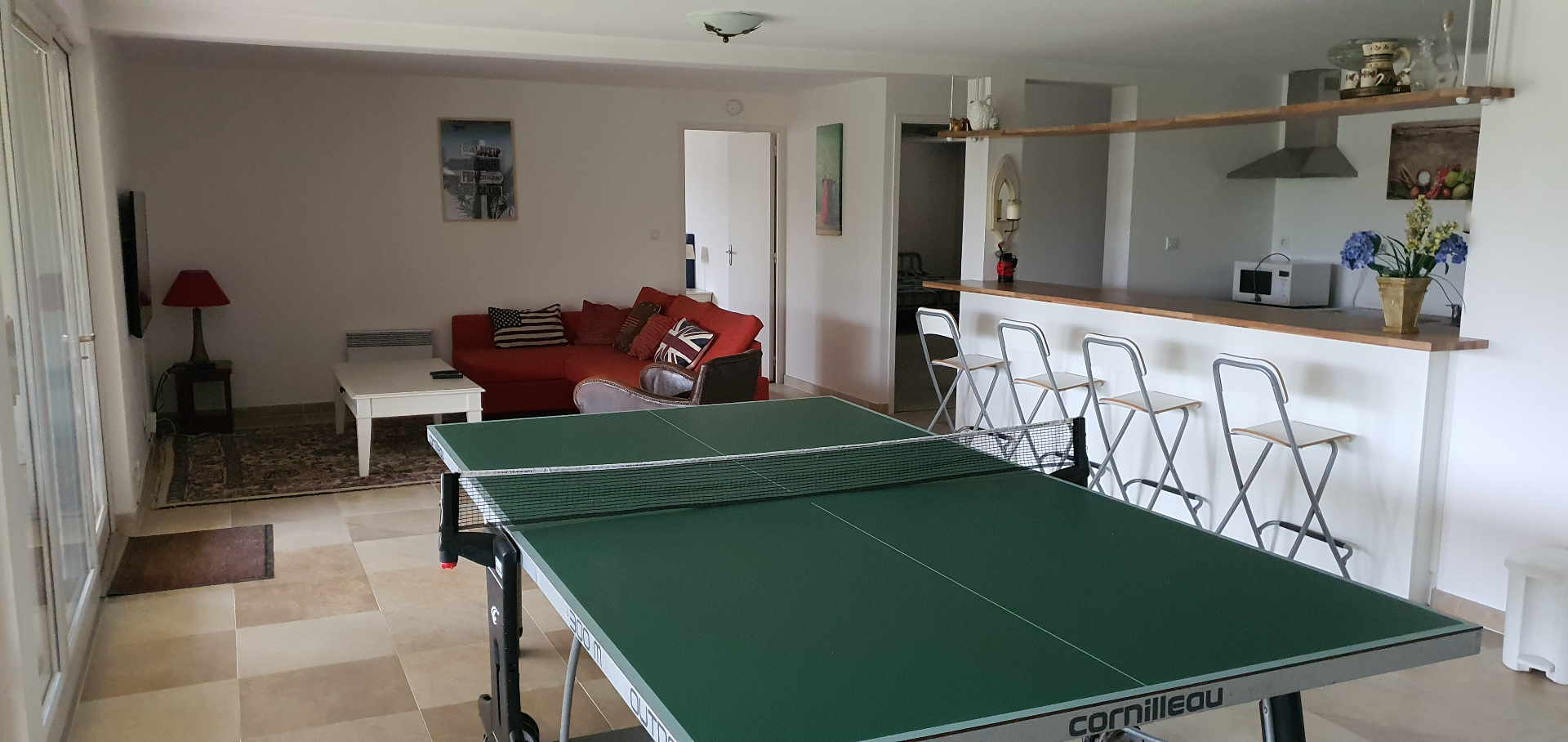 Relax woonkamer 2 met grote televisie, loungehoek, tafeltennis en bar met ingerichte keuken op de benedenverdieping